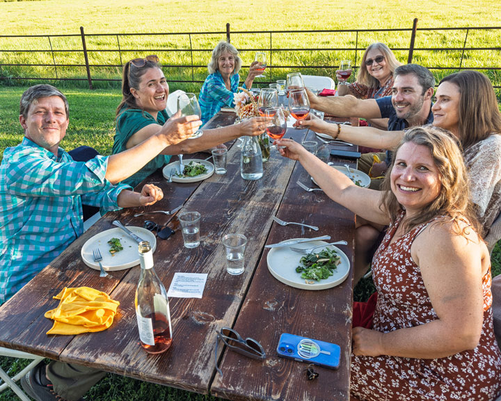 Graphic featuring a multi-course menu and the Forage Sisters. Text highlights a fundraiser for World Central Kitchen. Visuals of local produce and Alfred Eames wine.