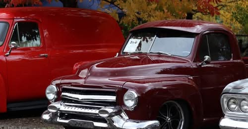 Classic maroon vintage car parked in historic Pioneer Town during the Cedaredge Applefest Car Show